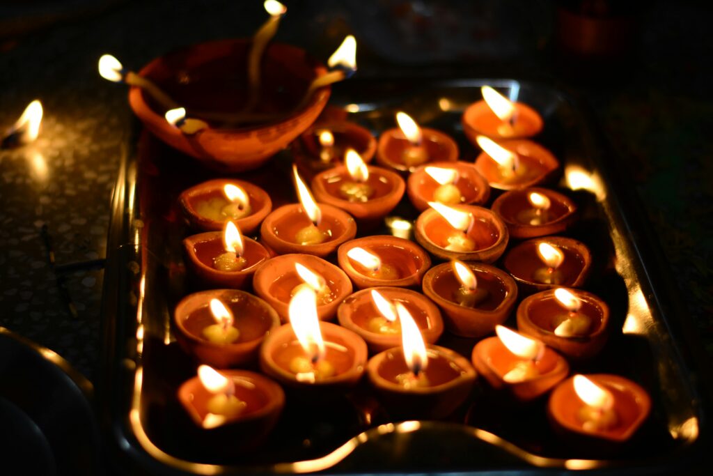 A close-up of glowing diyas on a tray during Diwali night, symbolizing light and warmth.